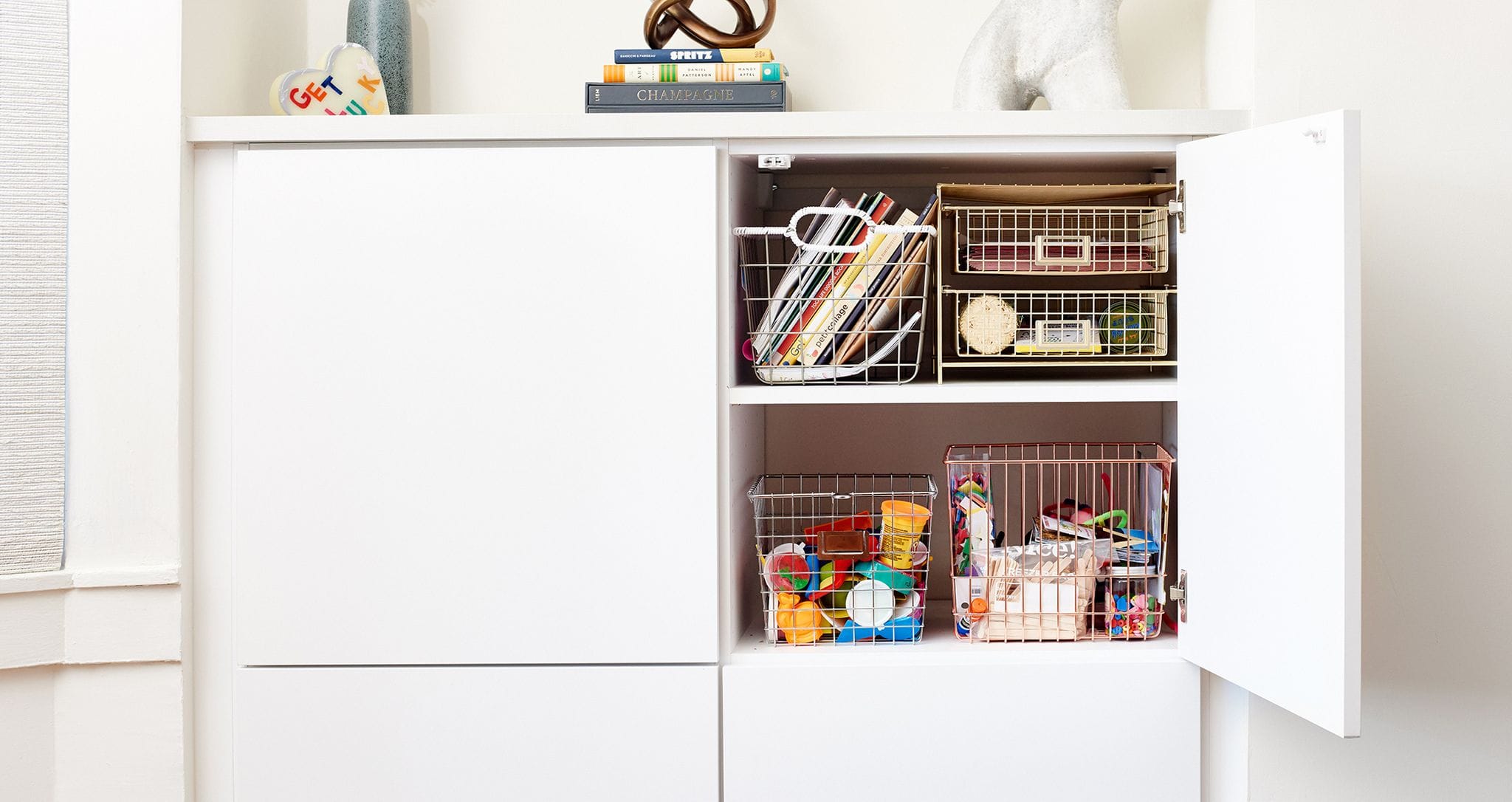 Custom built in cabinet storage for toys and books created by California Closets