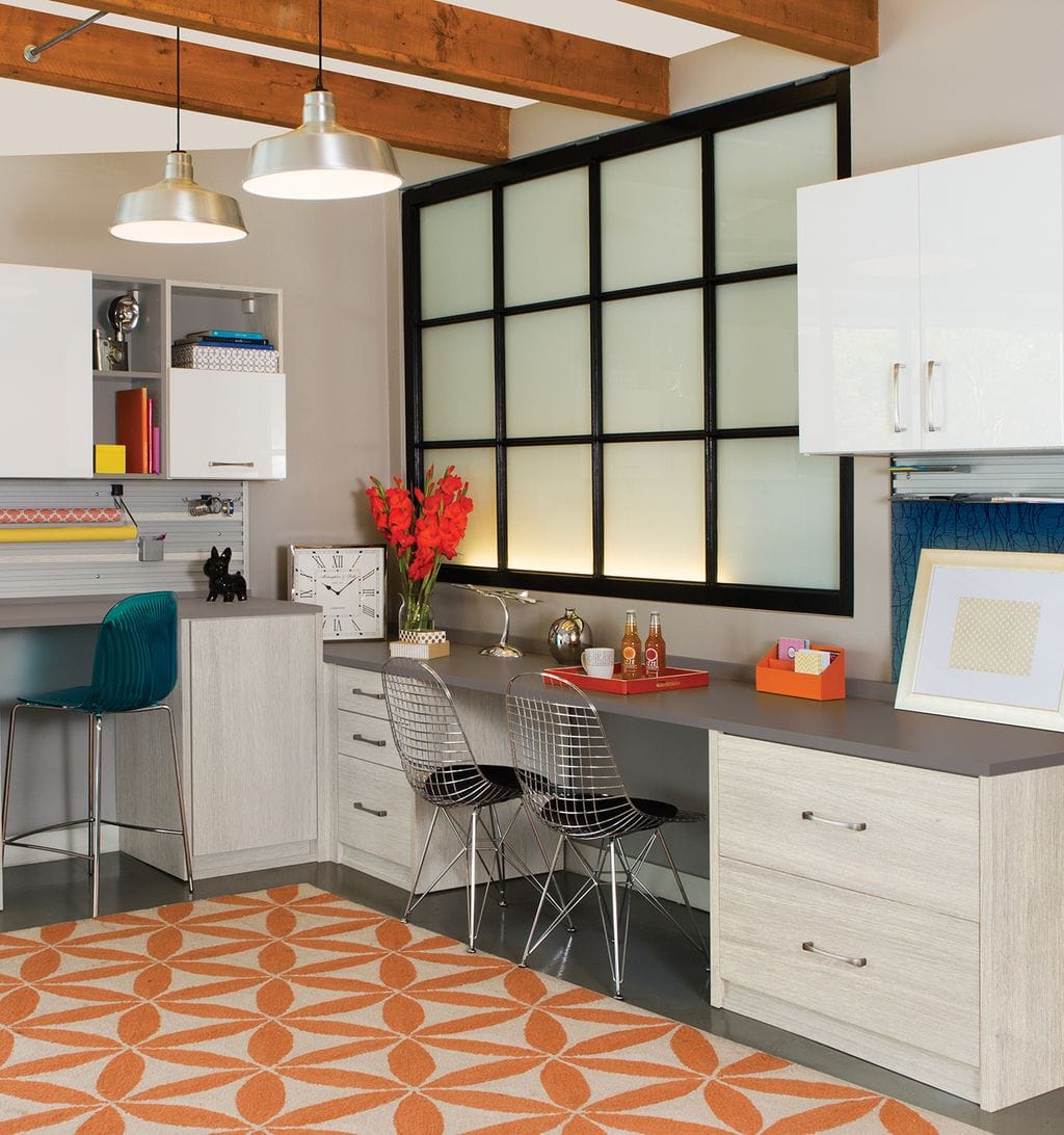 Craft room with dual workstations and storage cabinets by California Closets