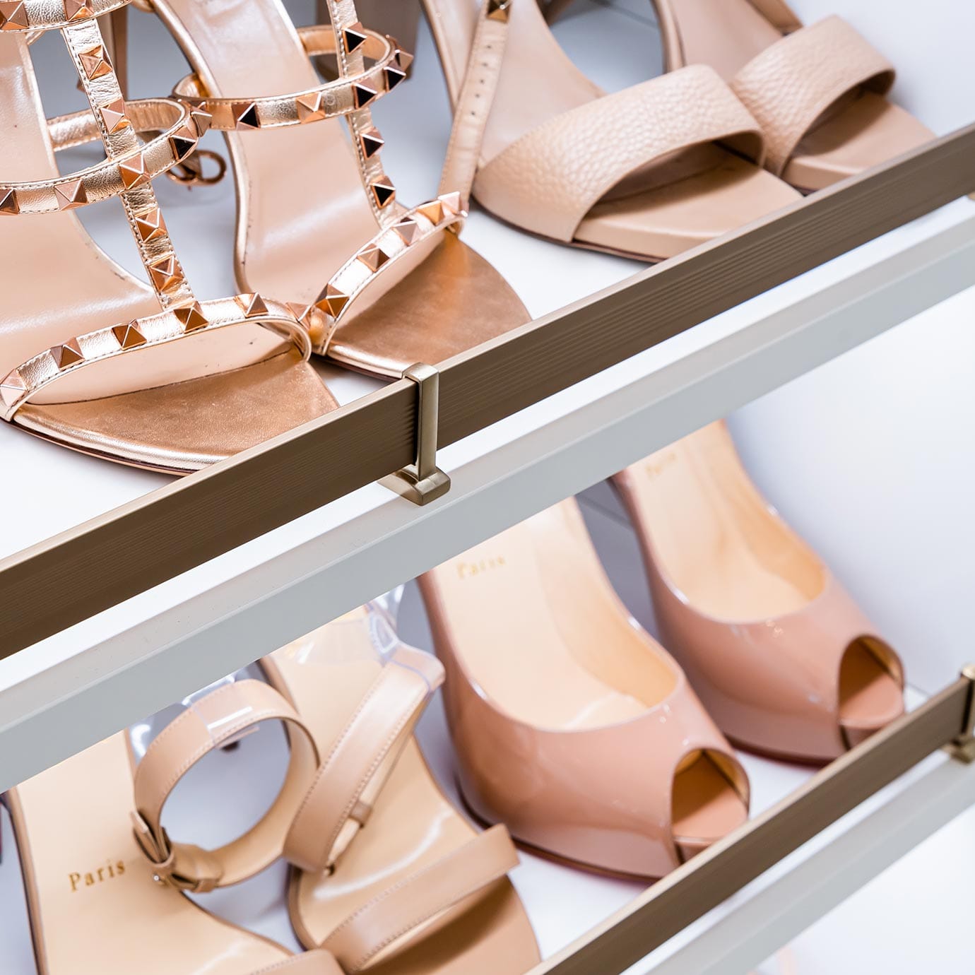 Custom built slanted shoe storage rack with toe guards by California Closets