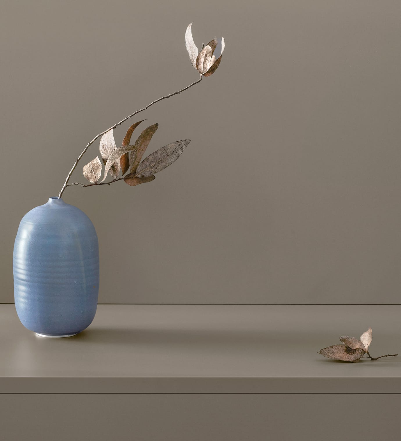 Custom grey wood grain finish shown with gloss vase and flowers created by California Closets