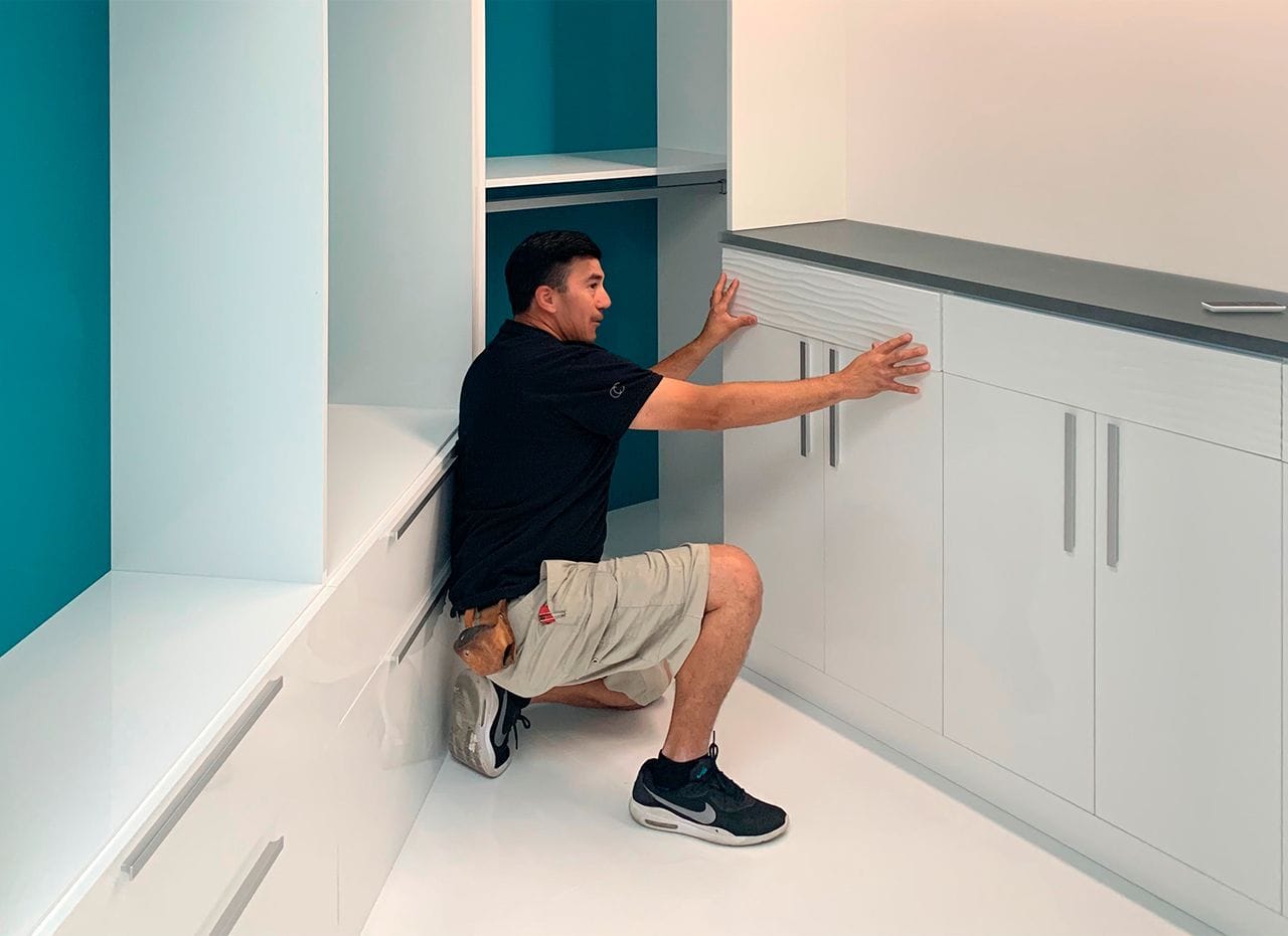 Process of installing a custom closet with the technician assembling drawer fronts from California Closets