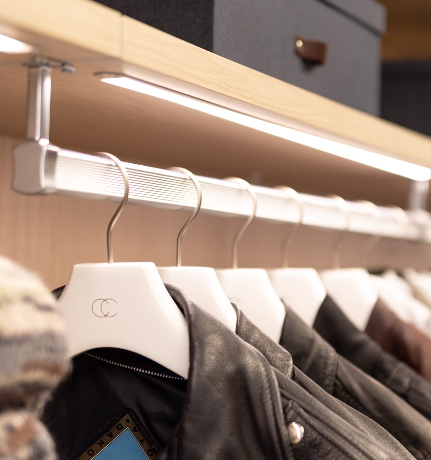 Wardrobe custom lighting above the clothing rail, open shelving by California Closets