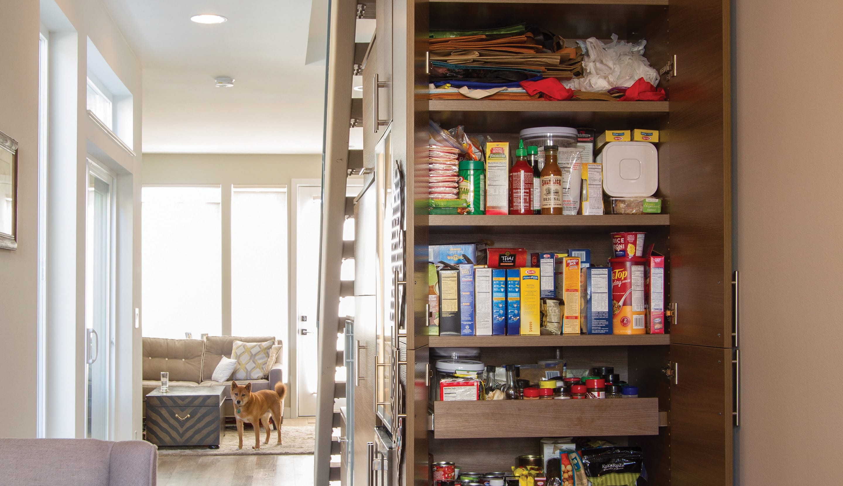 Installed kitchen pantry shelving and drawers in dark wood finish by California Closets