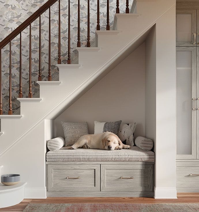 Entry way storage design with understairs bench and custom cabinets and drawers by California Closets
